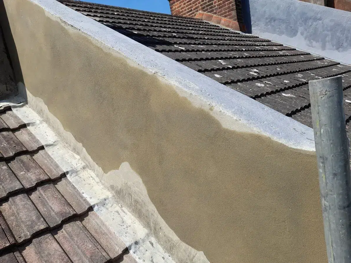 Rendered wall along the edge of a tiled roof.