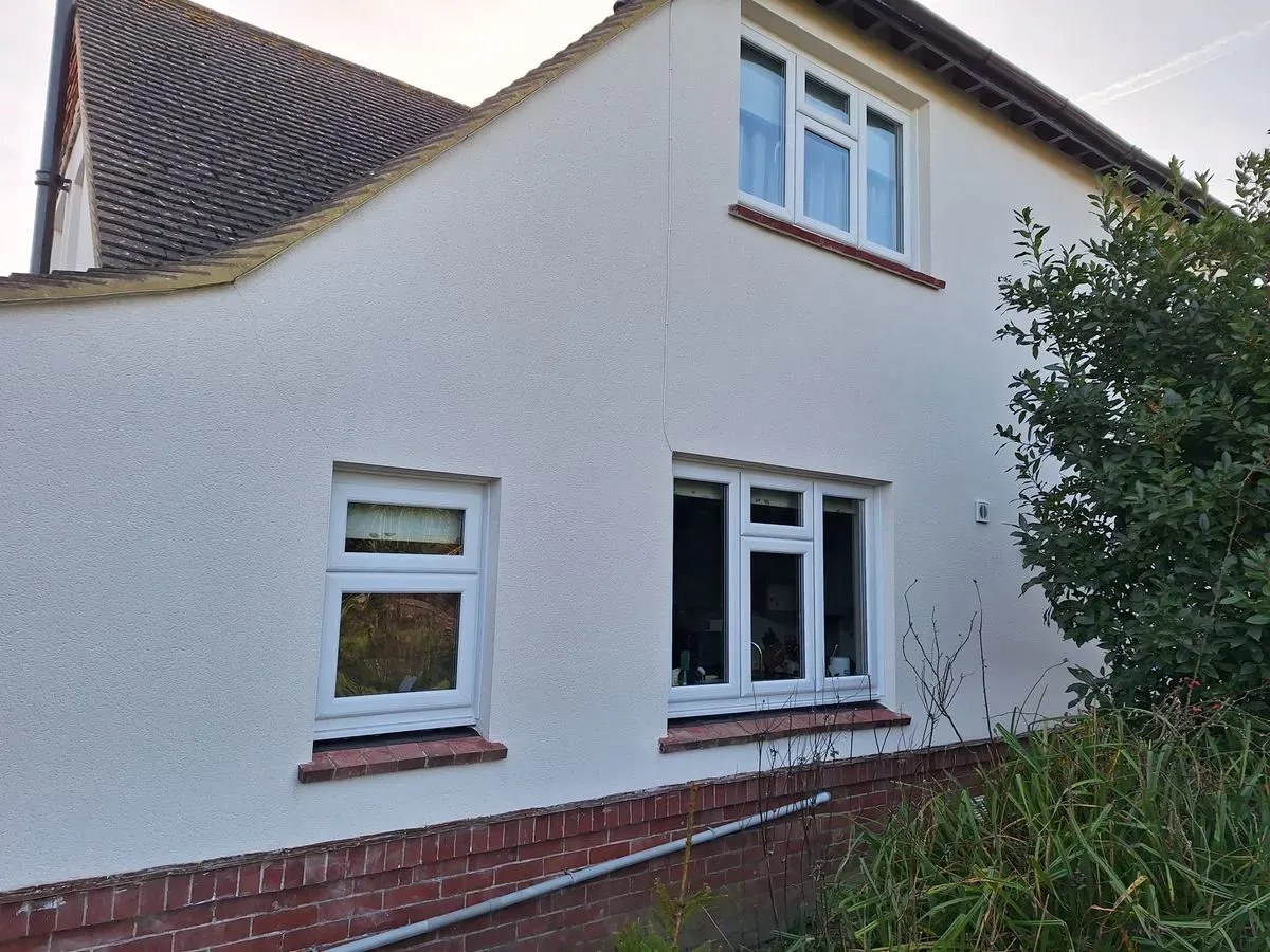 White-rendered house exterior with white-framed windows.